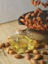Close-up of oil in jar by nuts on table