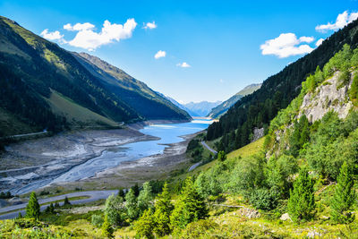 Scenic view of mountains and river against blue sky
