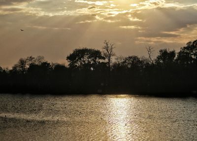 Scenic view of lake against sky at sunset