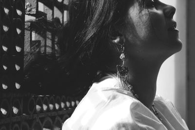 Close-up side view of woman against window