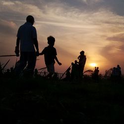 Silhouette men playing against sky during sunset