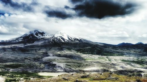 Scenic view of mountains against cloudy sky