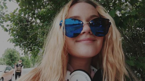 Portrait of a smiling young woman against trees