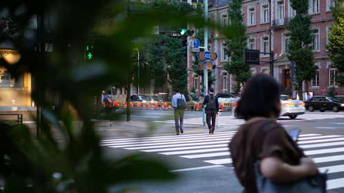 People walking on road in city