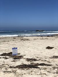 Scenic view of beach against clear blue sky