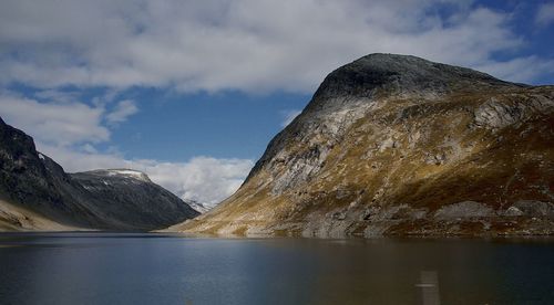 Scenic view of lake by mountains against sky