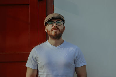 Portrait of young man standing against wall