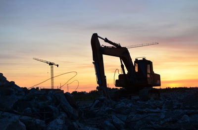 Construction site against sky during sunset