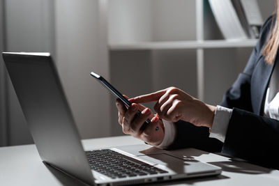 Midsection of businessman using laptop