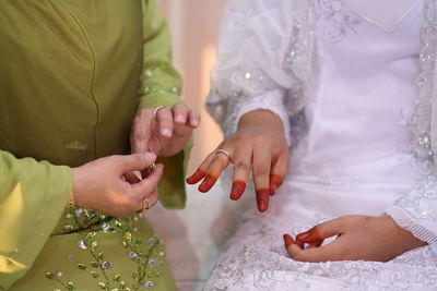 Midsection of women wearing rings