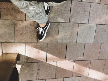 Low section of person standing on footpath
