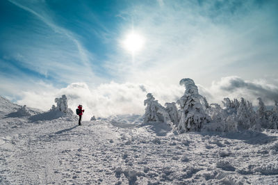 Full length of woman standing on snow covered landscape