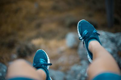 Low section of woman wearing shoes on cliff