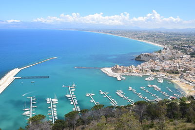 High angle view of sea by cityscape against sky