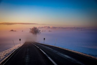 Road passing through snow covered landscape