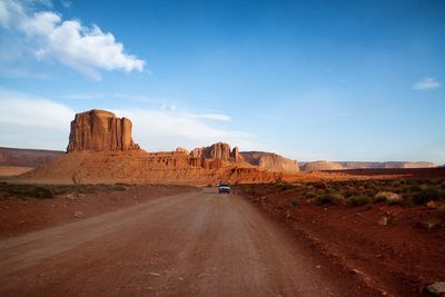 Road amidst rocks in desert against sky