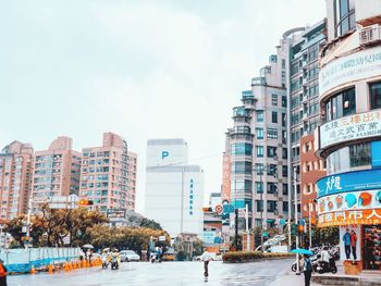 City street and buildings against sky