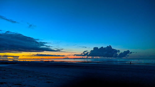 Scenic view of beach against sky at sunset