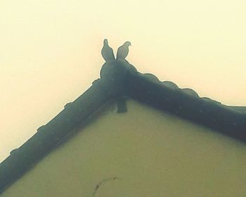 Low angle view of silhouette figurine on table against wall