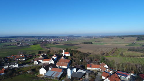 High angle view of houses against clear blue sky