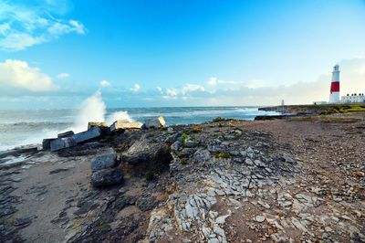 Portland bill lighthouse by sea against sky