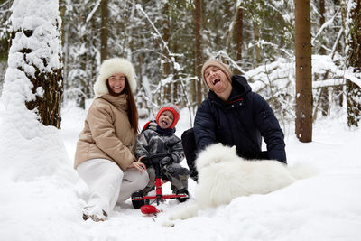 Side view of woman with dog on snow covered field