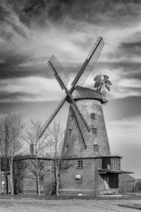 Traditional windmill on field against sky