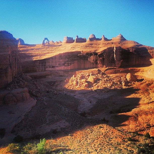 clear sky, tranquility, sunlight, landscape, desert, tranquil scene, blue, nature, arid climate, scenics, sand, beauty in nature, rock formation, non-urban scene, rock - object, copy space, mountain, shadow, remote, outdoors