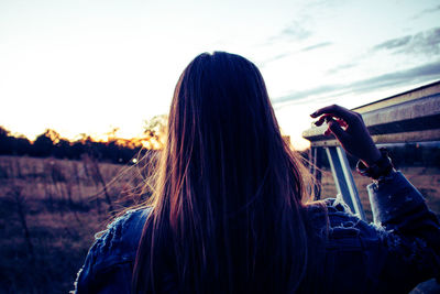 Rear view of woman on field against sky