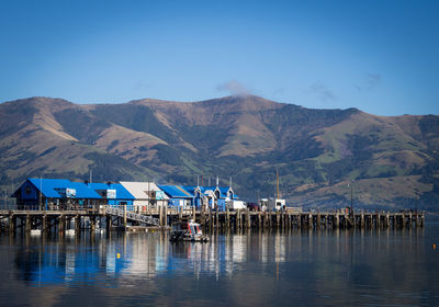 Scenic view of sea and mountains against blue sky