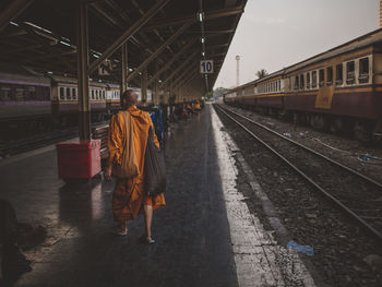 Monk walking on railroad station platform