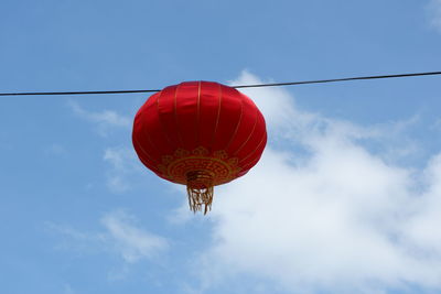 Low angle view of lanterns hanging against sky