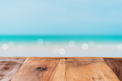 Close-up of wooden table against sea