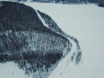 Snow covered road amidst field