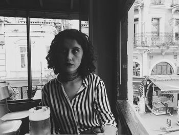 Portrait of young woman standing against wall