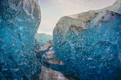 Rock formations by sea against blue sky