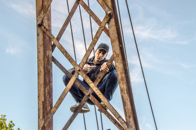 Low angle view of man working against sky