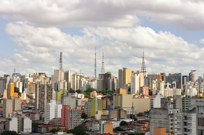 View of cityscape against cloudy sky