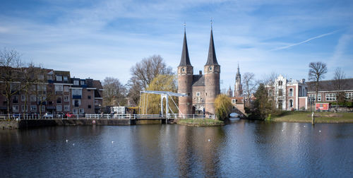 Buildings by river against sky