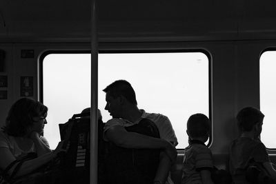 People standing by window of train