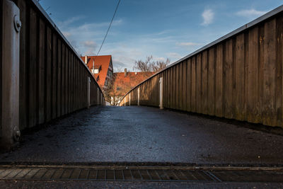 Footpath amidst buildings against sky