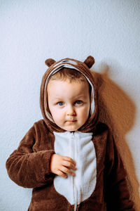 Little boy in pajamas in the form of a teddy bear with a hood