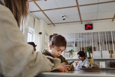 Girl in waiting room using cell phone