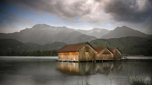 Scenic view of lake by buildings against mountains