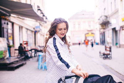 Portrait of smiling young woman on street in city