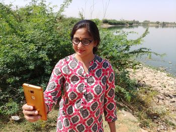 Portrait of woman standing against plants