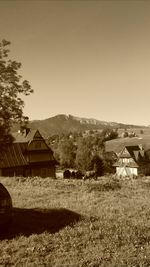 Houses on field against clear sky