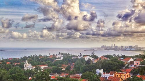 High angle view of houses by sea against sky