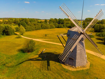 Traditional windmill on field against sky