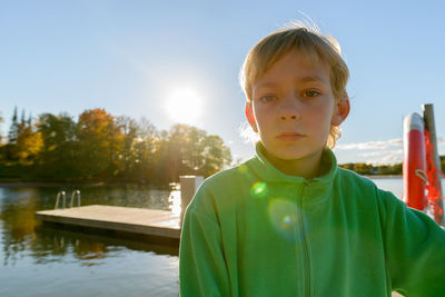 Portrait of boy standing against lake